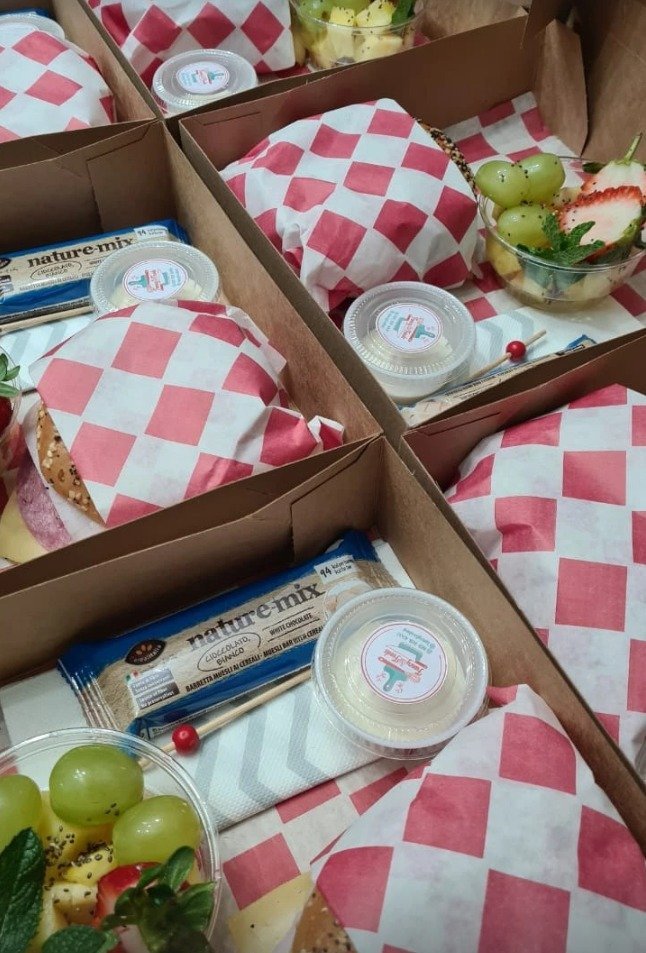 Boxes kraft con sándwich envuelto, fruta y barra de cereal